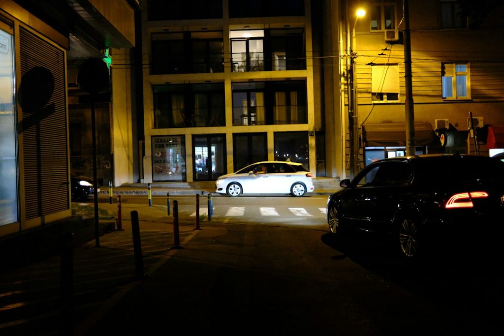 City street at night with cars and illuminated buildings, safe driver ride home in Dubai